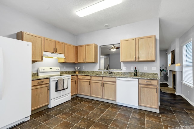 kitchen featuring stone counters, white appliances, ceiling fan, and sink