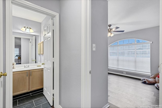 bathroom with ceiling fan and vanity