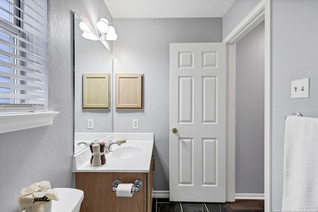 bathroom with tile patterned floors, a wealth of natural light, and vanity