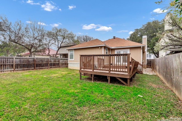 back of property featuring a wooden deck and a yard