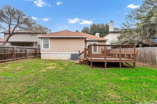 back of property with a lawn, central AC unit, and a wooden deck