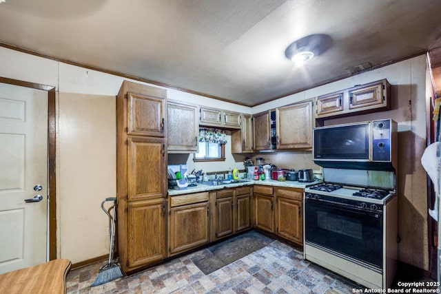 kitchen featuring white gas stove and sink