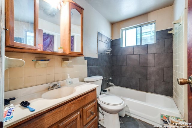 full bathroom with vanity, tiled shower / bath, decorative backsplash, toilet, and tile walls