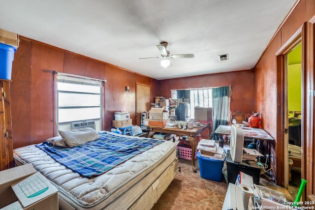 bedroom featuring ceiling fan, light carpet, and wood walls