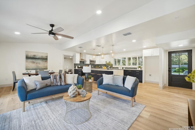 living room with ceiling fan and light hardwood / wood-style flooring