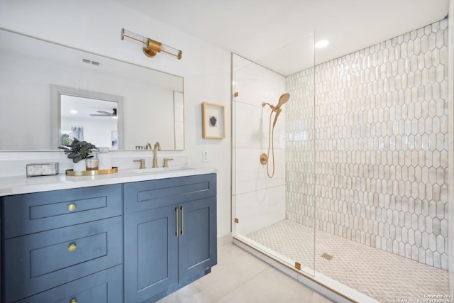 bathroom with ceiling fan, tile patterned flooring, vanity, and a shower with shower door