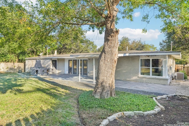 back of house featuring a lawn, a patio area, and central air condition unit