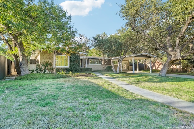 ranch-style home featuring a carport and a front lawn