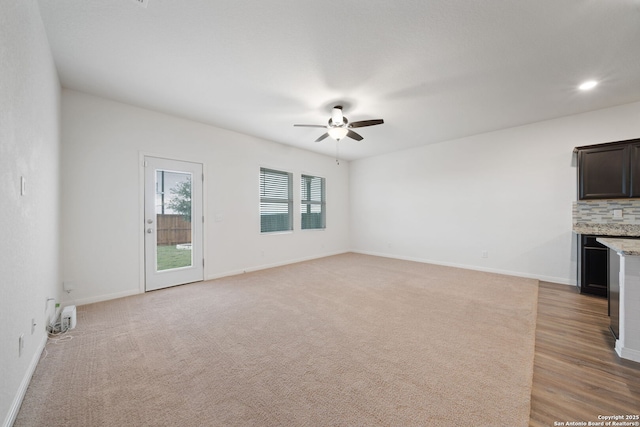 unfurnished living room with ceiling fan and light carpet