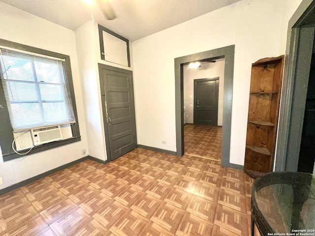 unfurnished bedroom featuring cooling unit and parquet flooring