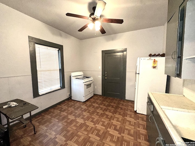 kitchen featuring dark parquet flooring, ceiling fan, and white appliances