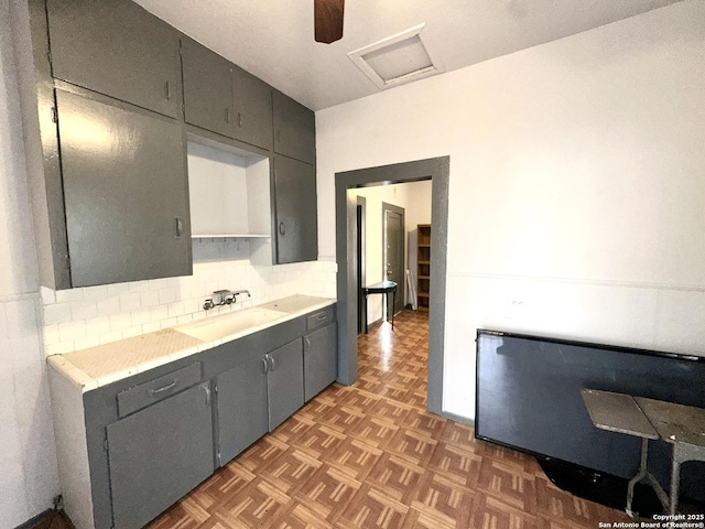 kitchen with backsplash, dark parquet flooring, and sink