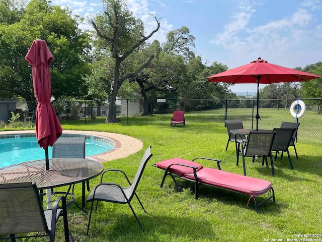 view of pool featuring a lawn