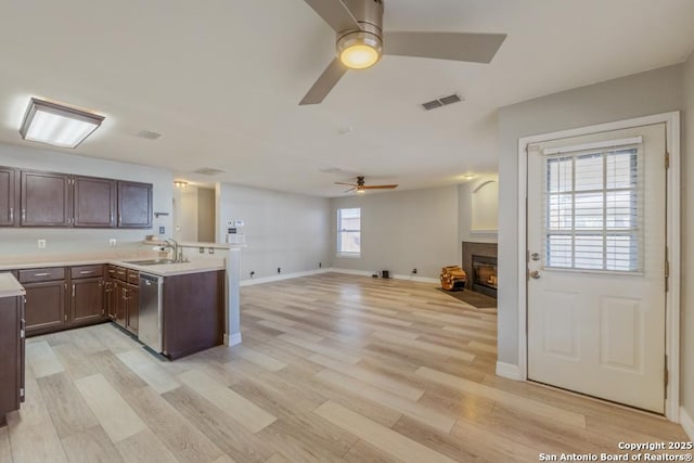 kitchen with kitchen peninsula, dishwasher, sink, and plenty of natural light