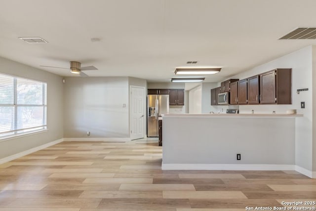 kitchen with dark brown cabinetry, stainless steel appliances, ceiling fan, and light hardwood / wood-style floors