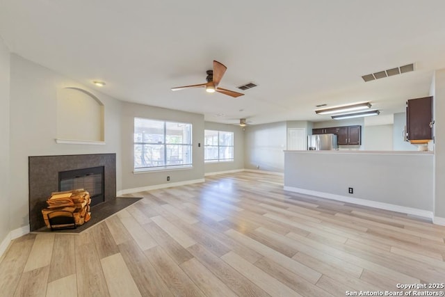 unfurnished living room with ceiling fan and light hardwood / wood-style floors