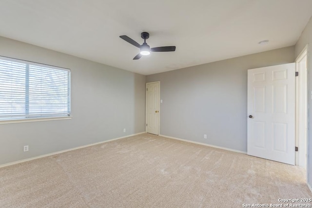 carpeted spare room featuring ceiling fan