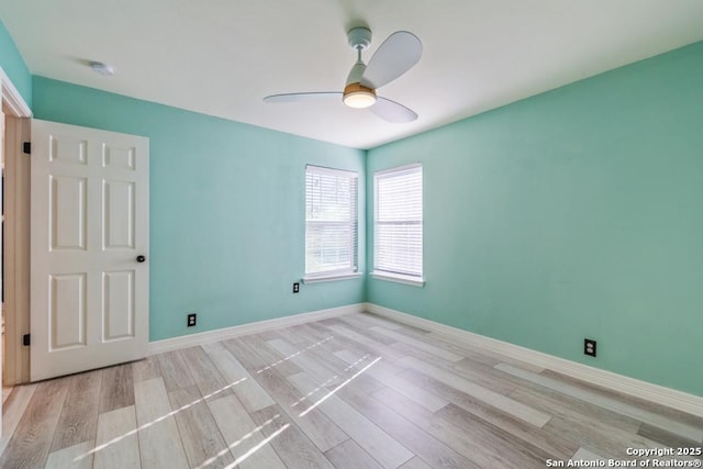 empty room with ceiling fan and light hardwood / wood-style flooring