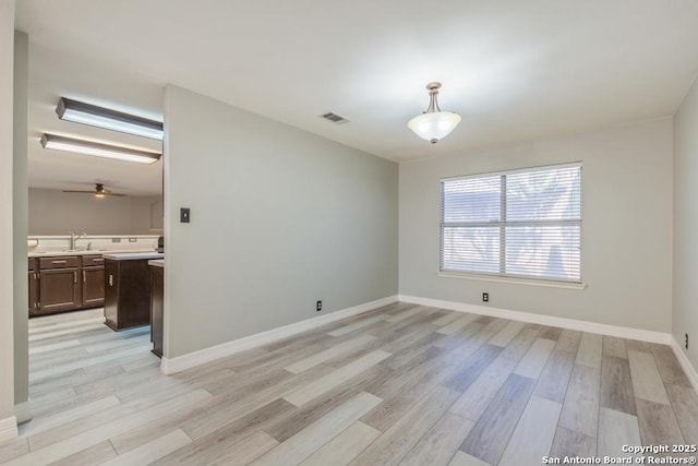 spare room with ceiling fan, light hardwood / wood-style floors, and sink