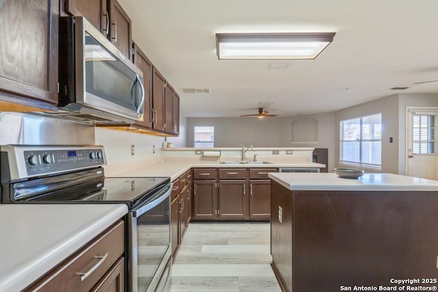 kitchen with a wealth of natural light, sink, a center island, and appliances with stainless steel finishes