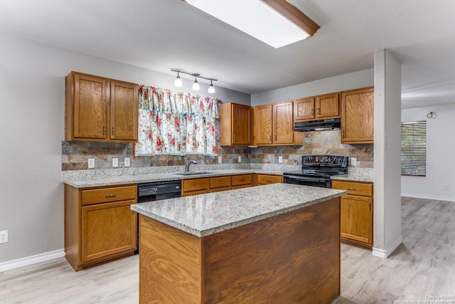 kitchen featuring sink, a center island, light stone counters, backsplash, and black appliances