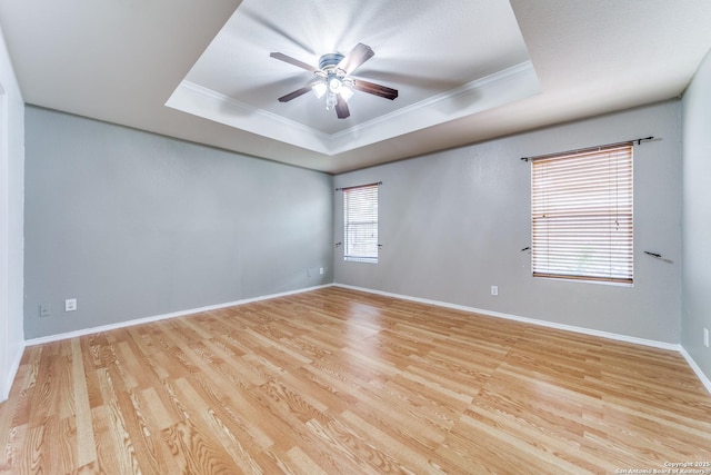 spare room with light hardwood / wood-style floors, a raised ceiling, ceiling fan, and crown molding