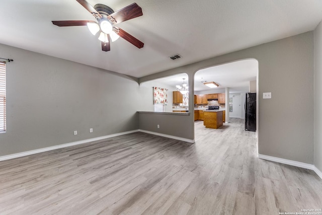 unfurnished living room featuring light wood-type flooring and ceiling fan