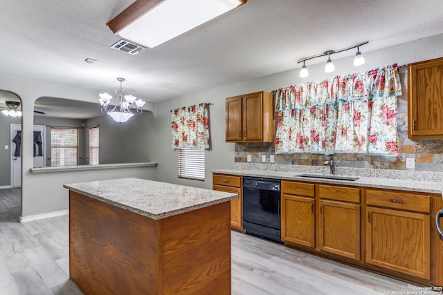 kitchen featuring sink, black dishwasher, light hardwood / wood-style flooring, backsplash, and a kitchen island