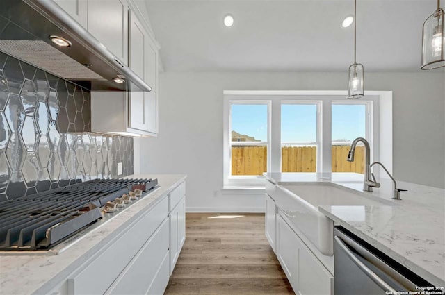 kitchen featuring white cabinetry, sink, decorative light fixtures, decorative backsplash, and appliances with stainless steel finishes