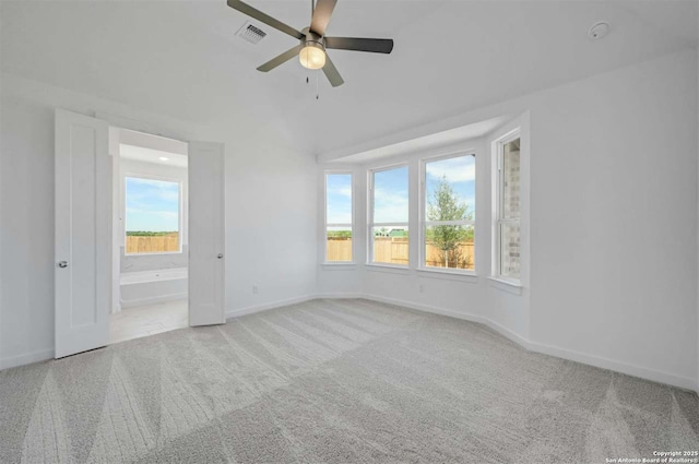 spare room with light carpet, a wealth of natural light, and ceiling fan