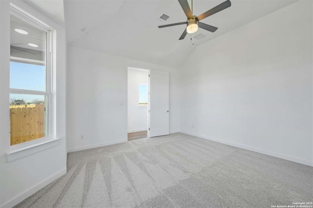 empty room with light carpet, vaulted ceiling, and ceiling fan