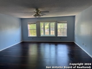 unfurnished room with ceiling fan and a textured ceiling