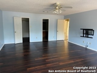 interior space featuring dark hardwood / wood-style floors, ceiling fan, and a textured ceiling