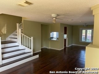 interior space with ceiling fan, wood-type flooring, and a textured ceiling