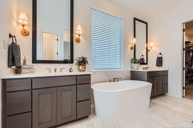 bathroom with a tub and vanity