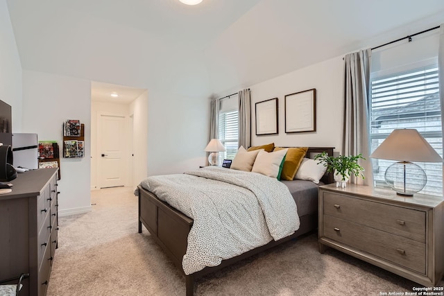 bedroom with lofted ceiling and light carpet