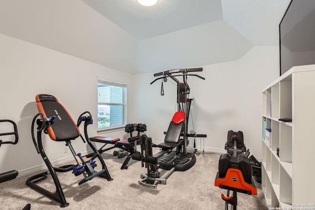 exercise room featuring carpet flooring and vaulted ceiling