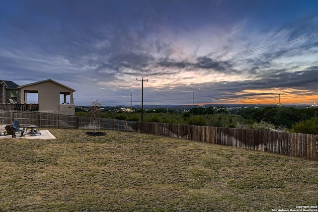 yard at dusk featuring a patio area