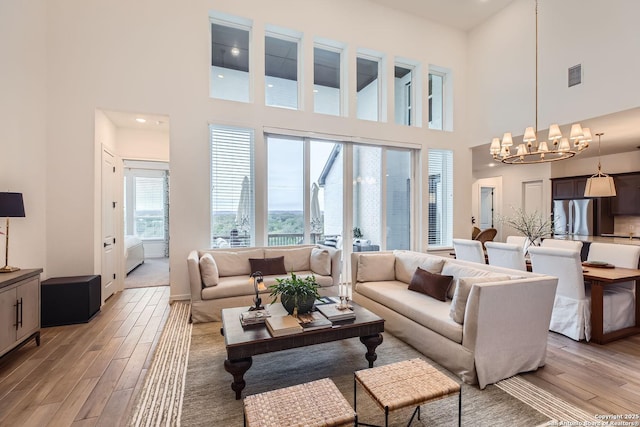 living room featuring a towering ceiling and an inviting chandelier