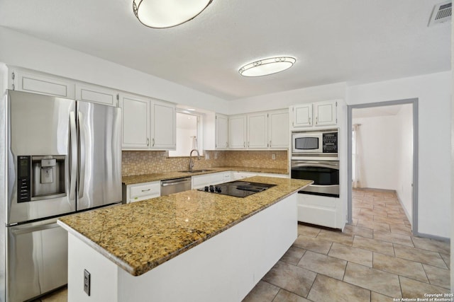 kitchen with a center island, sink, appliances with stainless steel finishes, tasteful backsplash, and white cabinetry