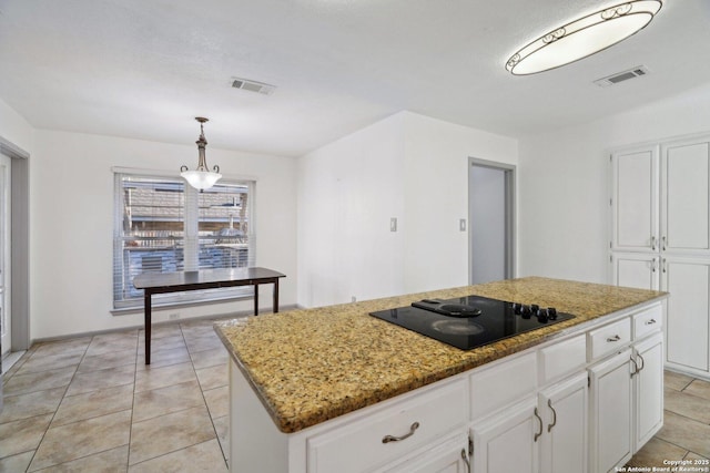 kitchen with a center island, black electric cooktop, hanging light fixtures, and white cabinetry