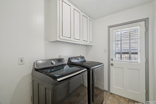 laundry area with light tile patterned floors, cabinets, and independent washer and dryer