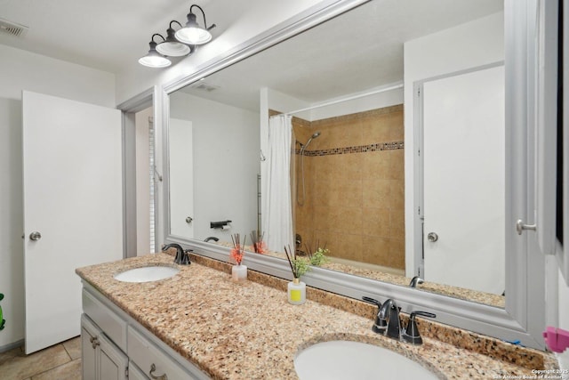 bathroom with tile patterned flooring, vanity, and walk in shower