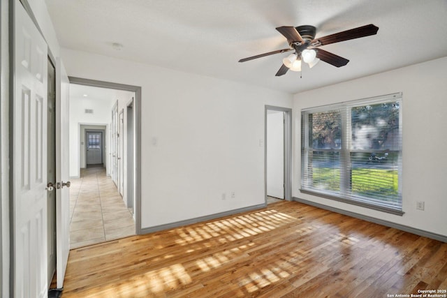 unfurnished room with light wood-type flooring and ceiling fan