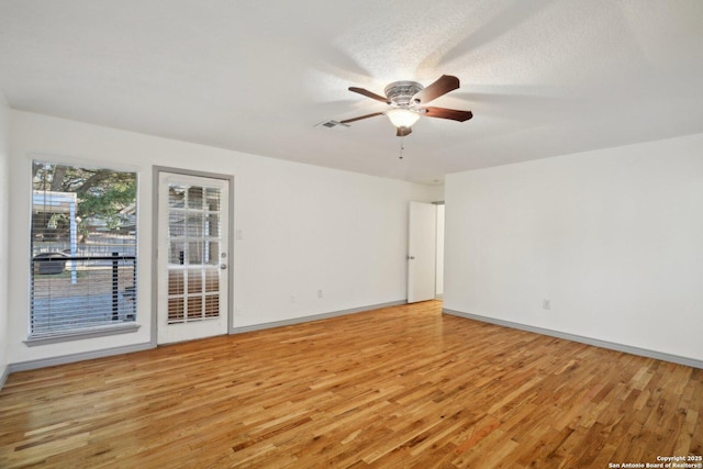 spare room featuring a textured ceiling, light hardwood / wood-style floors, and ceiling fan