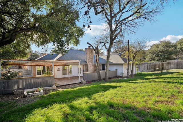 back of house featuring a deck and a lawn