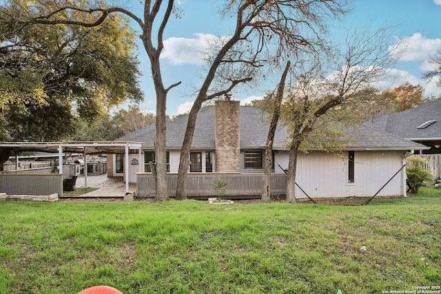 rear view of property featuring a lawn