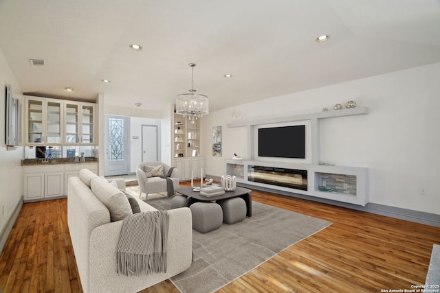 living room featuring light wood-type flooring and a chandelier