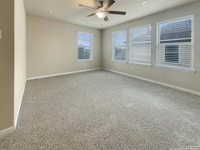 carpeted spare room with ceiling fan