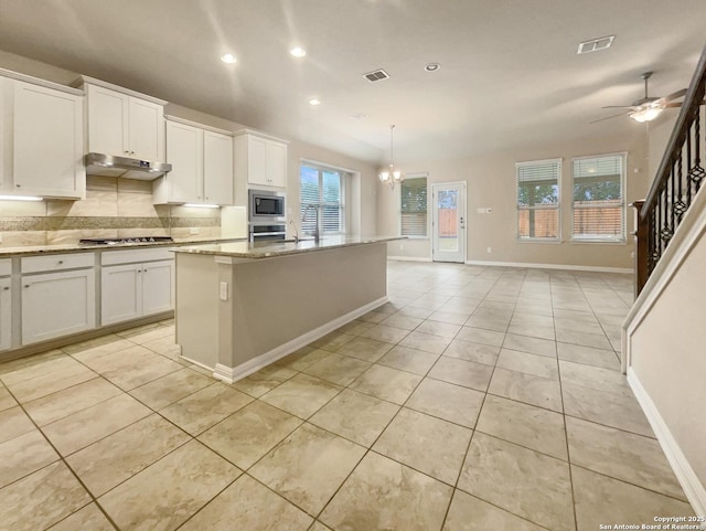 kitchen with pendant lighting, a center island, white cabinets, and stainless steel appliances